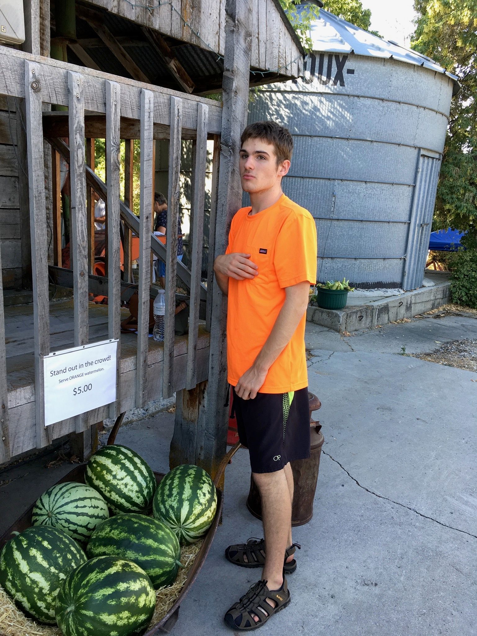 Derek at the Farmer's Market, with his prize orange watermelons.